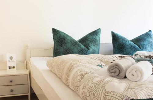 a bed with blue pillows and towels on it at Villa Viriditas in Elbingerode