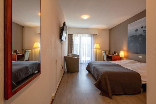 Cette chambre comprend deux lits et un bureau. dans l'établissement Hotel Brasserie Rebecca, à De Waal