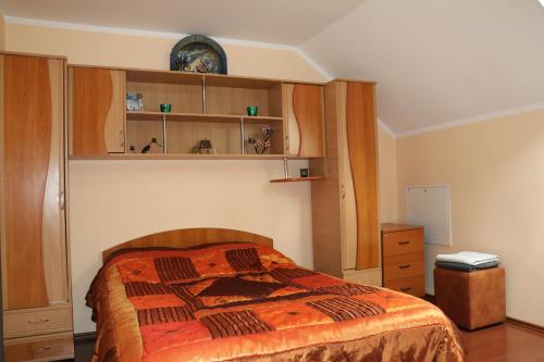 a bedroom with a bed and wooden cabinets at Amelia House in Făgăraş
