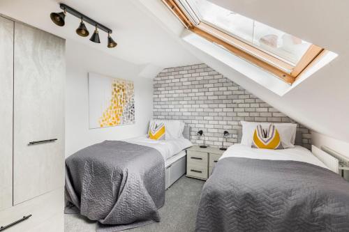 two beds in a room with a loft at Surrey Stays - 4 bedroom house, sleeps 9, 2 bathrooms, CR5, near Gatwick Airport in Banstead