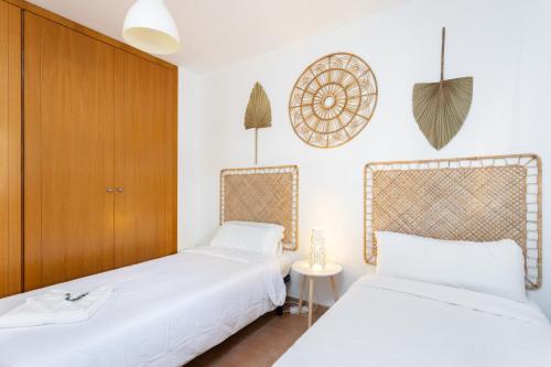 two beds in a room with white walls at 148 Paradise Sunny Home By Sunkeyrents in Adeje