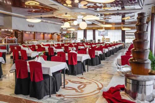a banquet hall with white tables and red chairs at Aquapark Health Resort & Medical SPA Panorama Morska All Inclusive in Jarosławiec