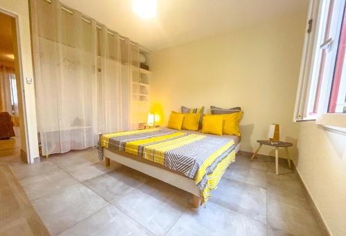 a bedroom with a bed with yellow pillows at L'Hermitage - Appartement T3 en bord de plage in Filaos
