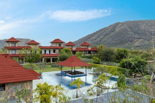 uma vista aérea de um resort com montanhas ao fundo em Anandam - Jacuzzi & Private Pool Villas in Udaipur em Udaipur