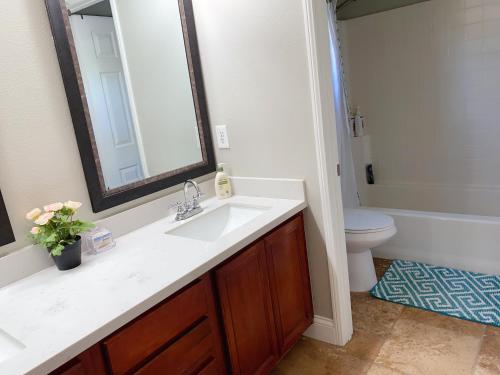 een badkamer met een wastafel, een toilet en een spiegel bij Cozy and comfortable #201 Room in Corona