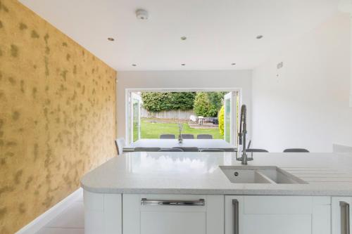 cocina con fregadero y ventana en Surrey Stays - 5bed house, sleeps 12, CR5, near Gatwick Airport, en Coulsdon
