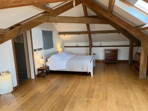 um quarto com uma cama e piso em madeira em The Old Stable Block - Flat 2 em Wadebridge