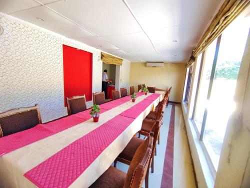 伊斯蘭堡的住宿－Margalla View Motel，一张长桌子,房间带椅子和红色的墙壁