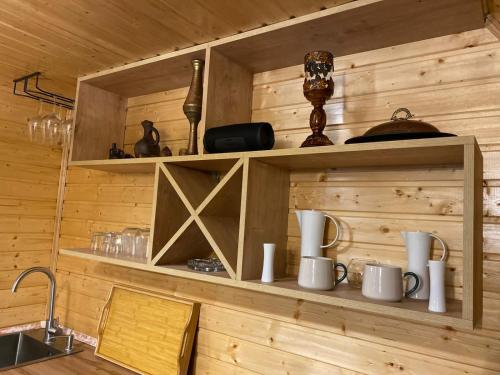 a kitchen with wooden walls and shelves with mugs at Silent Hill მშვიდი გორა in Batumi