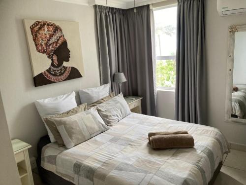 a bedroom with a large bed with a large window at Cozy, 2 bedroom beachfront apartment in Ballito