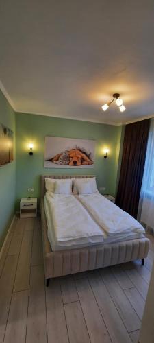 a bedroom with a bed with a painting on the wall at Pamy's Residence in Timişoara