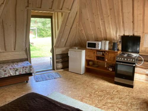 - une cuisine équipée d'une cuisinière et d'un réfrigérateur dans une cabine dans l'établissement Kakulaane Tourism Farm, à Lauküla