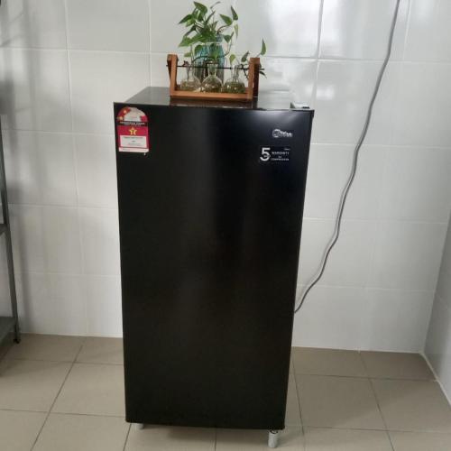 a black refrigerator with a plant on top of it at Homestay King Putrajaya sebelah Alamanda in Putrajaya
