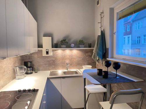 una pequeña cocina con fregadero y ventana en Cozy Modern Apartment with Small Balcony in the Heart of Berlin en Berlín