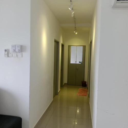 a hallway with white walls and a green door at Homestay King Putrajaya sebelah Alamanda in Putrajaya
