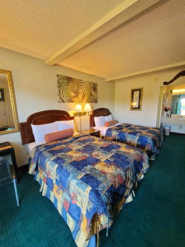 Express Inn and Suites في غاستونيا: غرفه فندقيه سريرين في غرفه