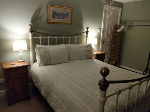 a bedroom with a large bed with a wooden night stand at Appletree House 