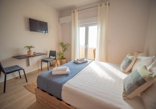 a bedroom with a large bed with a window at Mare Blue Bliss with SeaView by 8essentially in Heraklio