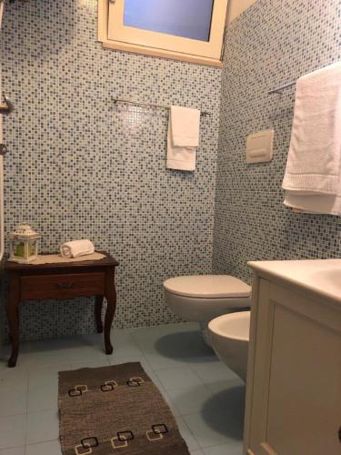 a bathroom with a toilet and a sink at Odegos Mono & Trilo in Torre dell'Orso