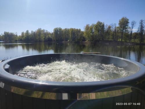 a bath tub in the middle of a lake at Pelakys Glamping Lounge in Šlepečiai