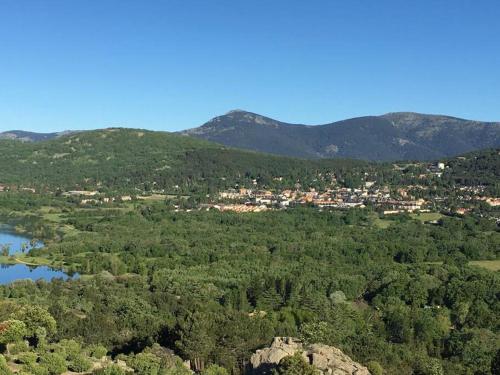 an aerial view of a town with a lake and mountains at NIMA Navacerrada in Navacerrada