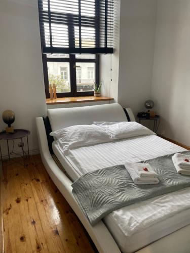 a white bed in a room with a window at Apartament w Centrum przy Studni 102m2 in Chełm