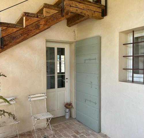 uma porta e uma cadeira ao lado de um edifício em Il Glicine - Natural BnB em Castello di Godego