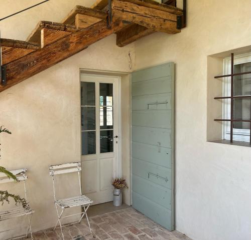 a door and a chair next to a building at Il Glicine - Natural BnB in Castello di Godego