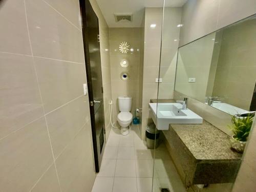 ein Badezimmer mit einem WC, einem Waschbecken und einem Spiegel in der Unterkunft The Haven 2 at One Eastwood Ave Tower 1 with Amazing View in Manila