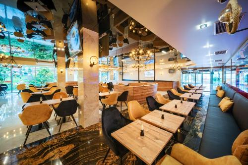 a restaurant with wooden tables and chairs at Aquapark Health Resort & Medical SPA Panorama Morska All Inclusive in Jarosławiec