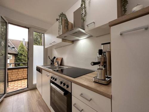 a kitchen with a sink and a stove top oven at Design Apt. Messe•HBF•Uniklinik in Essen