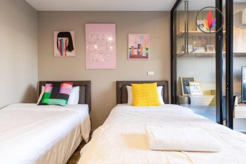 two beds sitting next to each other in a room at BTS S5 Surasak 900 meters near the Mekong River Pier Free Swimming Pool in Ferris Wheel Night Market Chinese Reception Bangkok Center in Ban Khlong Prawet