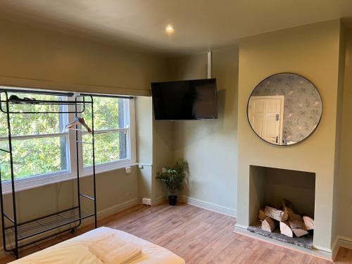 a bedroom with a fireplace and a mirror on the wall at The Ring O'Bells in Halifax