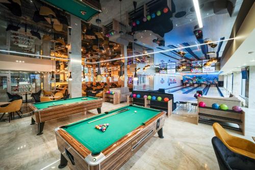 a billiard room with two pool tables and bowling lanes at Aquapark Health Resort & Medical SPA Panorama Morska All Inclusive in Jarosławiec