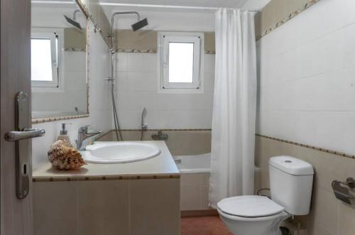 a bathroom with a sink and a toilet and a mirror at Yellow house in Palaiá Fókaia
