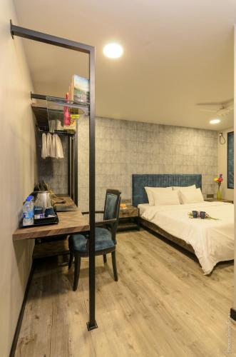 a bedroom with a bed and a desk and a mirror at Backpacker Cowies in Mumbai