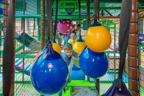 two children in a playground with blue and yellow balls at Aquapark Health Resort & Medical SPA Panorama Morska All Inclusive in Jarosławiec