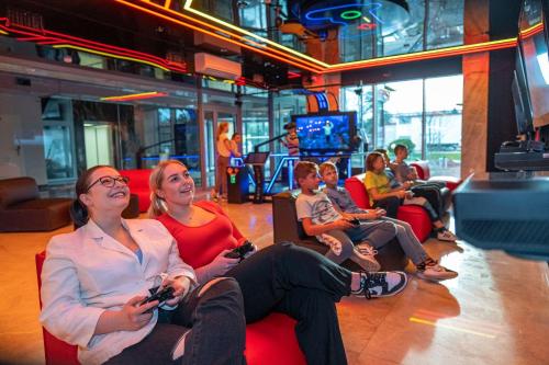 a group of people sitting in chairs playing a video game at Aquapark Health Resort & Medical SPA Panorama Morska All Inclusive in Jarosławiec
