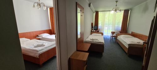 a hotel room with two beds and a mirror at Leśna Radość in Jastrząb