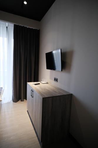 Vip Avtim hotel في أوجهورود: غرفة مع تلفزيون على جدار مع خزانة