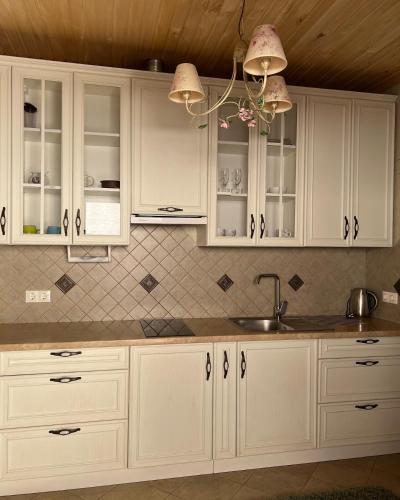 a kitchen with white cabinets and a sink at Вiлла Тераса in Polyana