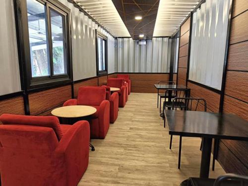 a waiting room with red chairs and tables and windows at Aurora Villas and Cabin Resort in Clark