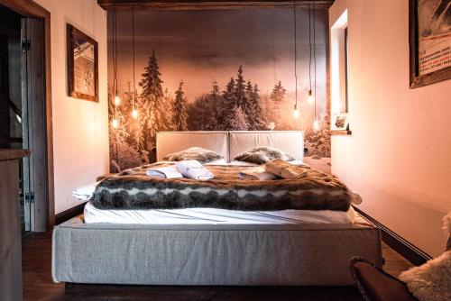 sypialnia z dużym łóżkiem z obrazem na ścianie w obiekcie Le Chalet Skalite w Szczyrku