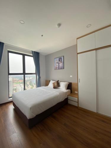 a bedroom with a large bed and a large window at Asahi Luxstay - Green Pearl Bắc Ninh Serviced Apartment in Hòa Ðình