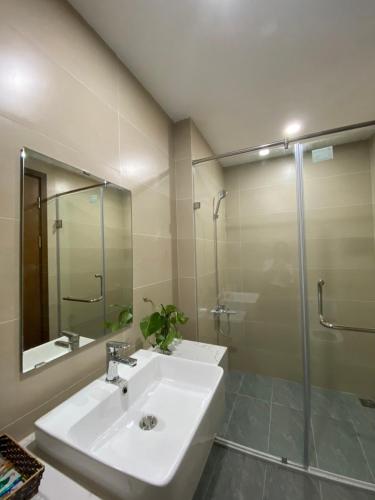La salle de bains est pourvue d'un lavabo et d'une douche en verre. dans l'établissement Asahi Luxstay - Green Pearl Bắc Ninh Serviced Apartment, à Hòa Ðình