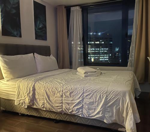 1 dormitorio con 1 cama grande y ventana en Destina Stays@ Air Residences Makati, Metro Manila, en Manila
