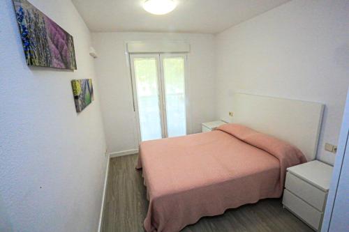 a small bedroom with a bed and a window at Grekus Litoral - ONLY FAMILIES in Cambrils