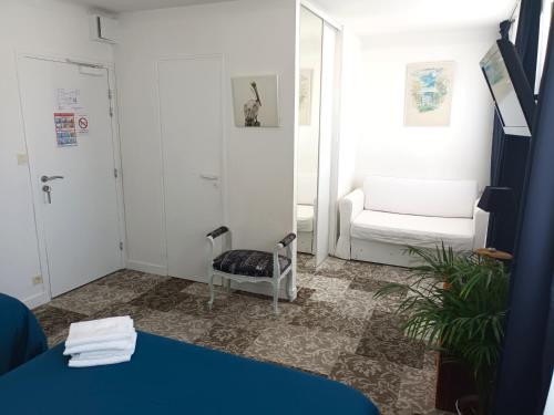 ein Wohnzimmer mit einem Stuhl und einem Spiegel in der Unterkunft Le vent des globes in Les Sables-dʼOlonne