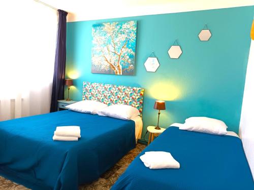 2 Betten in einem Zimmer mit blauen Wänden in der Unterkunft Le vent des globes in Les Sables-dʼOlonne