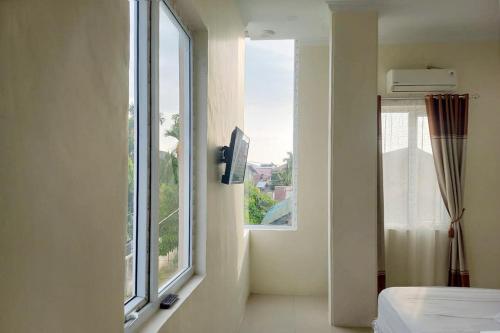 Urbanview Hotel Mulia Banda Aceh في باندا أسيه: غرفة مع نافذة بها سرير وإطلالة